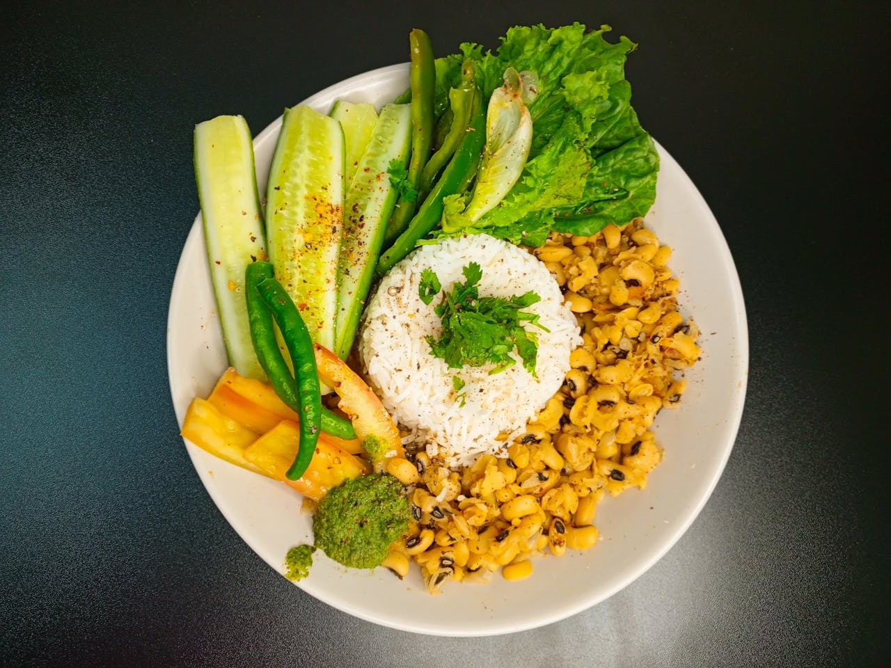 gallery-3 A vibrant plate of rice, beans, and fresh vegetables for a healthy vegetarian meal.